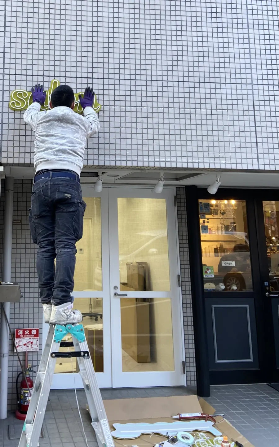 店舗の壁面に看板を取り付けている設置作業