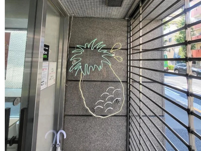 店舗の壁面に設置したパイナップルのネオンサイン