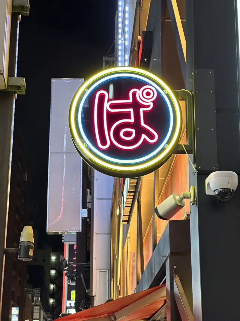 夜の街で点灯している丸型の袖看板